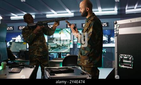 Les membres menant des opérations spéciales, chargeant des armes, se préparant à attaquer les forces ennemies. Gros plan du soldat de l'armée dans le centre de commandement emballant des armes pour la mission d'assaut, caméra B. Banque D'Images