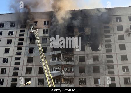 KHARKIV, UKRAINE - 15 SEPTEMBRE 2024 - des secouristes sur une plate-forme élévatrice éteignent un incendie dans le bâtiment résidentiel touché par une bombe aérienne guidée russe, Kharkiv, dans le nord-est de l'Ukraine Banque D'Images