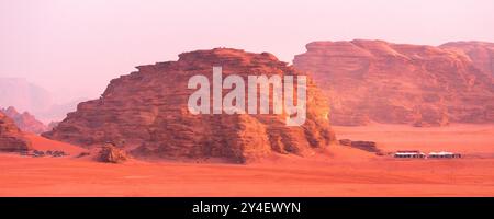 Jordanie, Wadi Rum soleil apparaît au-dessus de l'horizon, lever de soleil dans le désert, bannière de tentes de camp Banque D'Images