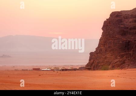 Jordanie, Wadi Rum soleil apparaît au-dessus de l'horizon, lever du soleil dans le désert, tentes de camp Banque D'Images