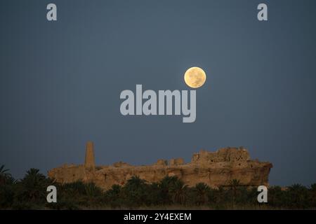 Oasis de Siwa, Égypte. 18 septembre 2024. Une super lune pleine connue ce mois-ci sous le nom de Moisson Lune est vue se coucher sur l'oracle de Zeus - Ammon. Crédit : Dimitris Aspiotis/Alamy Live News Banque D'Images