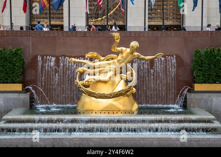 New York, New York - 16 mai 2024 : statue dorée du Rockefeller Centre avec ruisseau d'eau. Banque D'Images