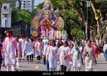 Mumbai, Inde : dans une procession pendant le festival annuel de Ganesh, une foule marche devant un char avec une grande statue du Dieu hindou éléphant Ganesh Banque D'Images