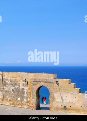 Maroc, Tanger : couple face à l’océan à la porte Bab Al Bahr, place de la Kasbah, porte donnant sur la baie Banque D'Images