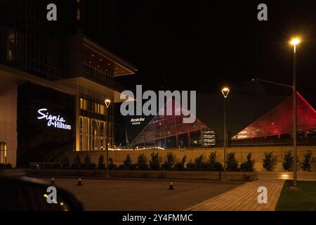 Un hall d'hôtel avec un grand panneau qui dit "Signa". Le lobby est éclairé la nuit, ce qui lui confère une atmosphère chaleureuse et accueillante Banque D'Images