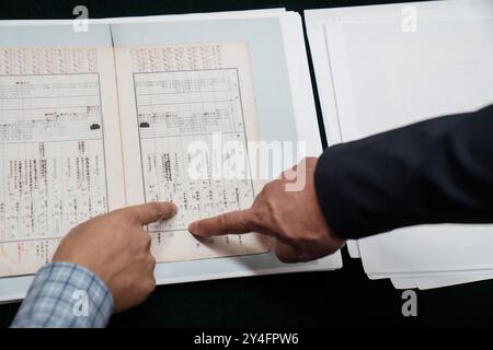 (240918) -- HARBIN, 18 septembre 2024 (Xinhua) -- Seiya Matsuno (R), un érudit japonais, également professeur distingué à l'Université internationale de Heilongjiang, et Jin Shicheng, un chercheur au Hall d'exposition des preuves du crime commis par l'unité 731 de l'Armée impériale japonaise, identifient une copie du document sur les informations des techniciens dans les détachements japonais de guerre contre les germes pendant la seconde Guerre mondiale, au centre de presse de Harbin, dans la province du nord-est de la province du Heilongjiang, le 17 septembre 2024. Seiya Matsuno, un érudit japonais, a dévoilé un nouveau document sur l'info Banque D'Images