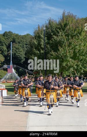 Avec le drapeau orné du lever en arrière-plan, les tuyaux et les tambours de la police Emerald Society du comté de Westcheter commencent une procession commémorative de 911. Banque D'Images