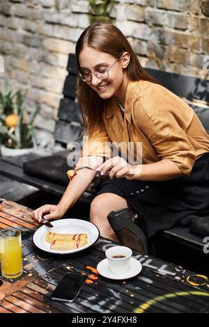 Une jeune femme avec un membre artificiel sourit tout en profitant d'un brunch dans un café, embrassant son style de vie quotidien avec joie. Banque D'Images