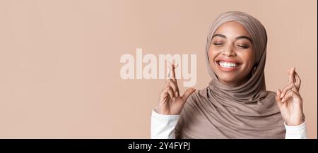 Gros plan portrait d'une fille musulmane noire rêveuse en foulard croisant les doigts Banque D'Images