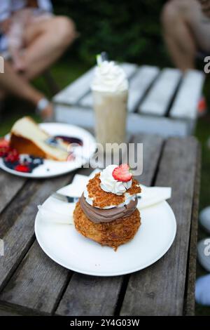 Dessert sucré avec baies, menthe, crème fouettée et biscuit sur une planche de bois. Nourriture saine, végétalienne, sans sucre, sans gluten et sans lactose. Dessert aux baies Banque D'Images