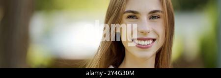 Une jeune femme joyeuse embrasse la nature, rayonnant de joie alors qu'elle aime la vie en plein air, mettant en valeur sa force et sa résilience. Banque D'Images