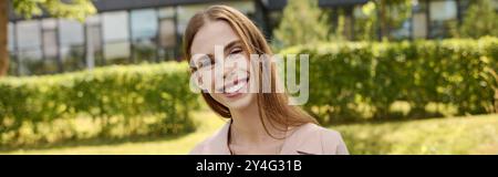 Une jeune femme profite d'une journée ensoleillée à l'extérieur, rayonnant de bonheur et de force alors qu'elle embrasse son voyage vers le bien-être. Banque D'Images