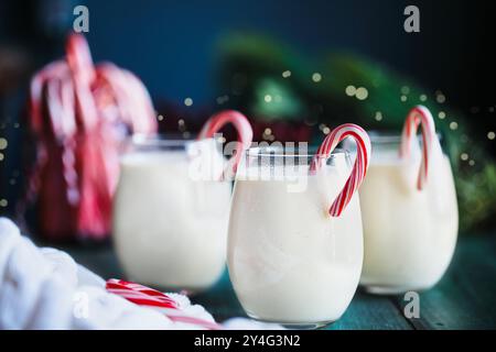 Trois verres de lait de poule crémeux avec des bonbons. Mise au point sélective avec arrière-plan festif flou. Banque D'Images