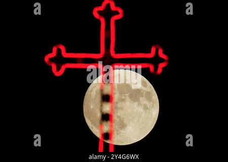 Aqosh, Irak. 17 septembre 2024. La pleine lune se lève derrière la croix du monastère de la Vierge Marie dans la ville irakienne d’Alqosh, à 50 km au nord de Mossoul. Crédit : SOPA images Limited/Alamy Live News Banque D'Images