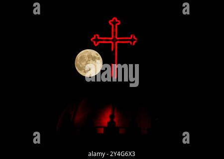 Aqosh, Irak. 17 septembre 2024. La pleine lune se lève derrière la croix du monastère de la Vierge Marie dans la ville irakienne d’Alqosh, à 50 km au nord de Mossoul. Crédit : SOPA images Limited/Alamy Live News Banque D'Images