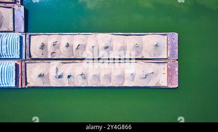 Vue aérienne de haut en bas des barges de chargement avec sable sur Green Water Banque D'Images