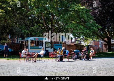 Exeter Cathedral Yard, Devon, Angleterre, Royaume-Uni : les habitants et les touristes se détendent autour d'un café et de gâteaux achetés dans le wagon de rafraîchissement de la cathédrale Banque D'Images