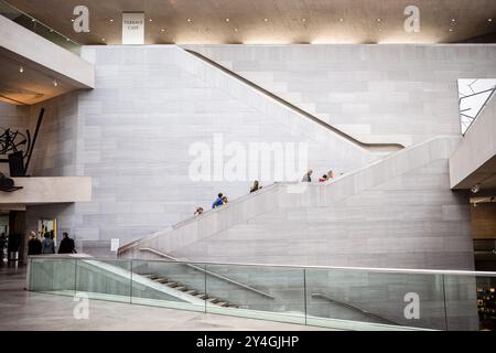 Marches menant à l'atrium de l'East Building à la National Gallery of Art à Washington DC personnes utilisant une pierre construite dans un mur de pierre A. Banque D'Images