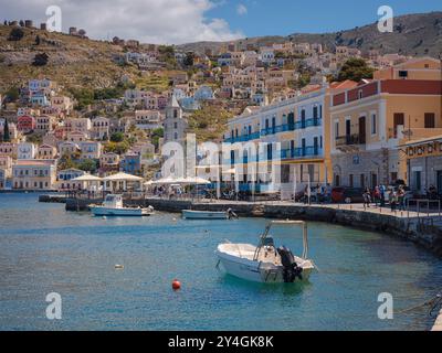 Île de Symi, Grèce - 20 avril 2023 : L'île de Symi est une petite île du Dodécanèse, qui étonne les visiteurs avec une atmosphère calme. petits bateaux de pêche dans la baie Banque D'Images