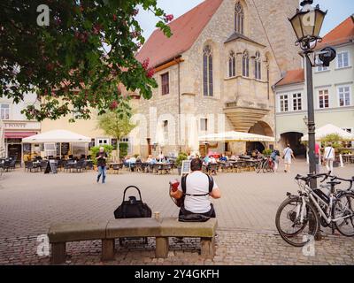 Erfurt, Allemagne - 21 mai 2023 : la place centrale Wenigemarkt en face du célèbre pont avec un café, une fontaine et un lieu pour une foire Banque D'Images