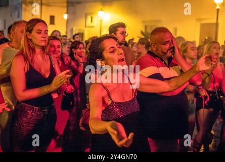Un mari et une femme dans une foule de gens italiens en train de se réjouir d'un concert nocturne gratuit en plein air sur la place de Depressa, un village des Pouilles, en Italie. Banque D'Images