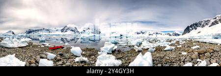 Un panorama haute résolution d'un kayak tiré vers le haut sur le rivage rocailleux à Cuverville Island sur la péninsule antarctique. Banque D'Images