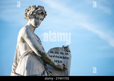 BRUXELLES, Belgique — la place des Martyrs abrite un monument central commémorant la Révolution belge de 1830. La figure féminine allégorique, tenant une tablette de pierre, est le point focal de cette place historique. Le site sert de lieu de repos final pour 466 martyrs morts en luttant pour l'indépendance belge des pays-Bas. Le monument et la place ont été conçus pour honorer ceux qui ont sacrifié leur vie pendant la révolution réussie qui a conduit à la création du Royaume de Belgique. Banque D'Images