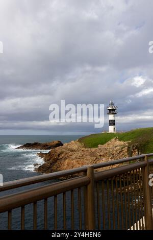 Phare en fin d'après-midi paysage côtier avec vagues calmes de l'océan et quelques nuages qui passent. Isla Pancha, Ribadeo, Espagne Banque D'Images