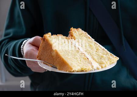 Une seule plaque grande portion d'un gâteau au citron fait maison servi à une table. Le gâteau a une garniture de crème au beurre au citron et un glaçage à la crème au beurre Banque D'Images