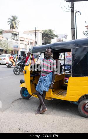 Mysore, Inde - 27 octobre 2023 : un Indien est debout devant une photo d'un pousse-pousse ou d'un tuk-tuk. Banque D'Images