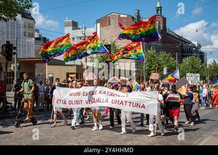 Des demandeurs d'asile LGBT russes défilent avec une bannière et des drapeaux arc-en-ciel déchirés lors du défilé de la fierté Helsinki 2023 sur Mannerheimintie à Helsinki, en Finlande Banque D'Images