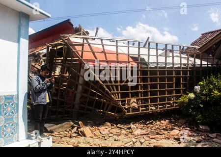 Bandung Regency, Indonésie. 18 septembre 2024. Un résident se tient devant une maison qui a été gravement endommagée après un tremblement de terre de magnitude 5,0 qui a frappé Cibereum Village, Bandung Regency, West Java, Indonésie le 18 septembre 2024. Selon des données temporaires de l’Agence régionale de gestion des catastrophes de Java Ouest, le séisme de magnitude 5,0 a fait 58 blessés. des blessés légers et 23 personnes ont été grièvement blessés, 491 logements, 5 établissements de santé, 9 établissements d'enseignement et 27 lieux de culte ont été endommagés. (Photo de Dimas Rachmatsyah/Sipa USA) crédit : Sipa USA/Alamy Live News Banque D'Images