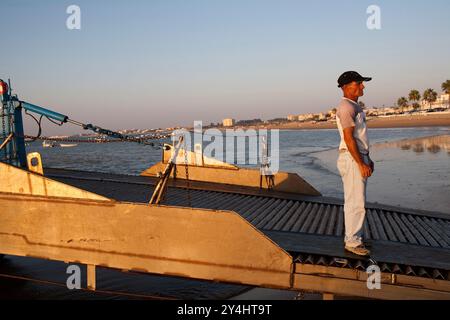 Séville, Espagne, 7 août 2008, Un marin se prépare à naviguer sur la barge à travers le fleuve Guadalquivir à la plage de Bajo de Guia pendant le coucher du soleil à Sanlucar de B. Banque D'Images