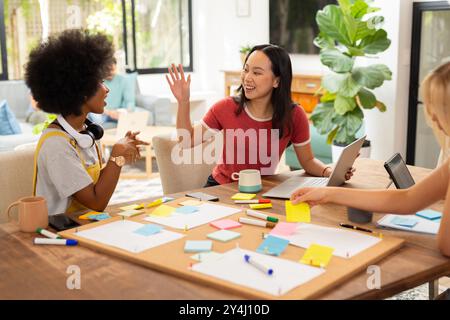 Collaboration sur le projet, brainstorming entre amis avec des notes adhésives et un ordinateur portable, démarrage d'entreprise Banque D'Images