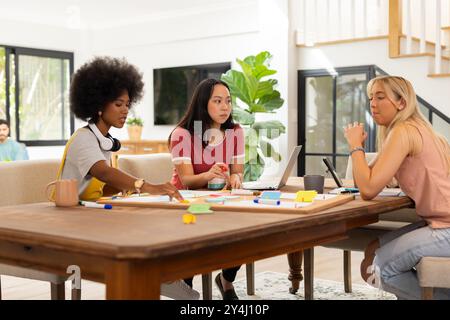 Collaboration sur le projet, brainstorming entre amis avec des notes adhésives et un ordinateur portable, démarrage d'entreprise Banque D'Images