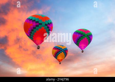 Trois montgolfières colorées contre un ciel de coucher de soleil en Arizona, États-Unis. Banque D'Images