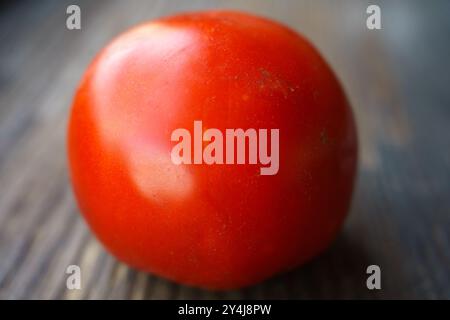 Gros plan sur la tomate rouge. Tomate sur une surface en bois. Banque D'Images