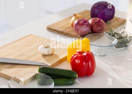 Préparer des légumes, de l'ail et des herbes sur une planche à découper dans une cuisine moderne Banque D'Images