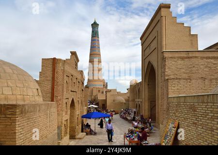 Khiva, Ouzbékistan - 15 septembre 2024 : Rue à Khiva et vue sur Islam Khodja Minaret au coucher du soleil à Ichan Kala, ancien centre-ville de la vieille ville K Banque D'Images