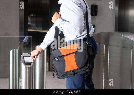 Numérisation de la carte d'identité, professionnel des affaires entrant dans l'immeuble de bureaux avec sac à bandoulière Banque D'Images