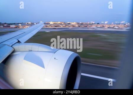 Wingview d'un avion à réaction moderne arrivant à l'aéroport de Hambourg dans la soirée Banque D'Images