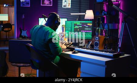 Ingénieur du son mixage et mastering de nouvelles musiques sur console et logiciel daw dans le home studio, en tournant les boutons de pré-ampli. Compositeur talentueux produisant des chansons pour l'industrie. Caméra B. Banque D'Images