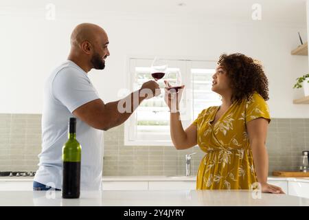 Griller avec des verres à vin, couple profitant du temps ensemble dans la cuisine moderne Banque D'Images