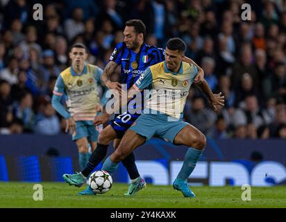 Manchester, Royaume-Uni. 19 septembre 2024. Rodri (R) de Manchester City est défié par Hakan Calhanoglu de l'Inter Milan lors du match de l'UEFA Champions League entre Manchester City et l'Inter Milan à Manchester, en Grande-Bretagne, le 18 septembre 2024. Crédit : Xinhua/Alamy Live News Banque D'Images