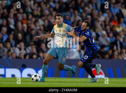 Manchester, Royaume-Uni. 19 septembre 2024. Rodri (l) de Manchester City est défié par Hakan Calhanoglu de l'Inter Milan lors du match de l'UEFA Champions League entre Manchester City et l'Inter Milan à Manchester, en Grande-Bretagne, le 18 septembre 2024. Crédit : Xinhua/Alamy Live News Banque D'Images