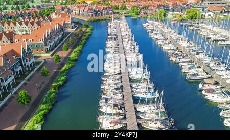 Vue aérienne par drone des maisons hollandaises modernes typiques et de la marina dans le port d'en haut, architecture du port de la ville de Volendam, Hollande du Nord, pays-Bas Banque D'Images