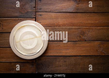 Vieille boîte de bobine de film de cinéma sur une planche en bois vintage rustique. Étiquette vierge avec espace de copie Banque D'Images