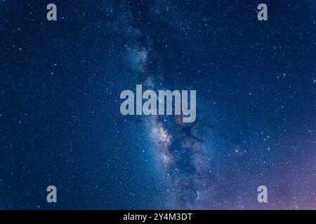 Une vue imprenable sur la voie Lactée qui s’étend à travers le ciel nocturne au-dessus d’une mer calme. La bande étoilée de notre galaxie est visible dans toute sa splendeur. Suao Banque D'Images