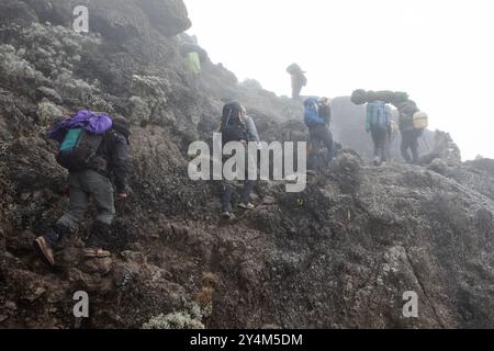 Randonneurs grimpant le mur raide et difficile de Barranco lors de leur ascension vers le sommet du Kilimandjaro. Banque D'Images