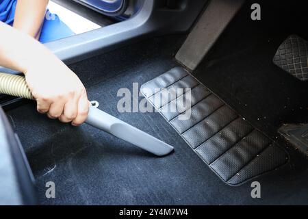 Homme nettoyant tapis de sol de voiture avec aspirateur, gros plan Banque D'Images